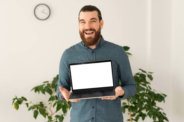 Portrait of happy smiling office worker man holding laptop with white blank screen for copyspace stock photo