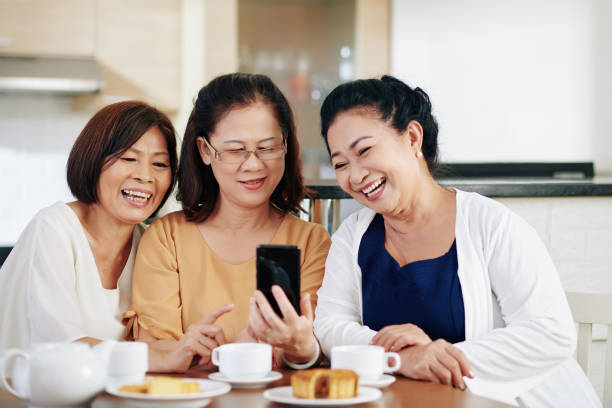 istock Friends looking at funny photos 1298258455