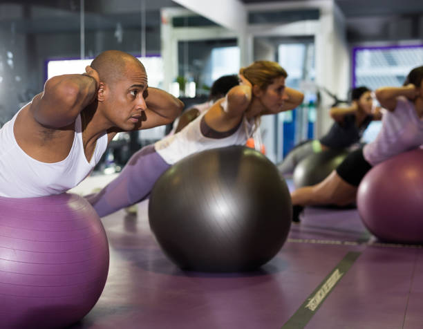istock Young man doing exercises with fitness ball 1298258601
