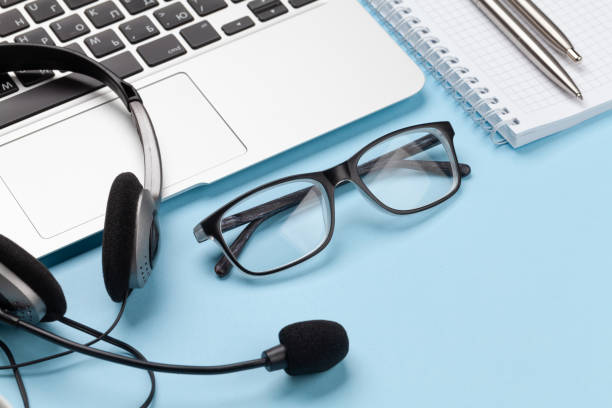 istock Office desk with headset, glasses and laptop 1298259955