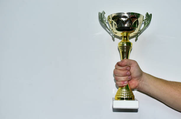 istock Sports cup in a man's hand on a white background. 1298260302