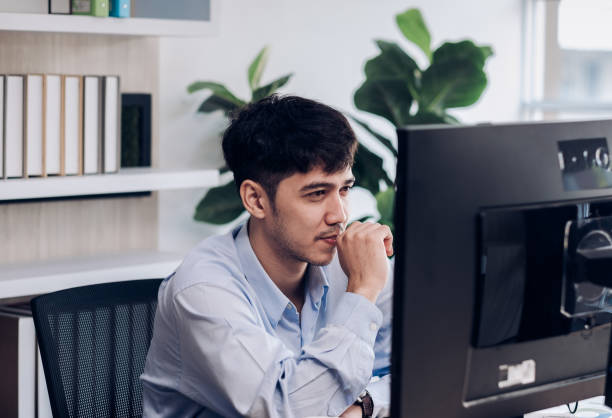 istock asian businessman working and looking at desktop computer screen for online trade at table in modern office. 1298260450