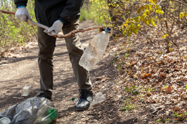 istock Man in white gloves collects plastic dishes in bag 1298261752