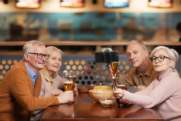 istock Senior Friends Taking Selfie in Bar 1298262448
