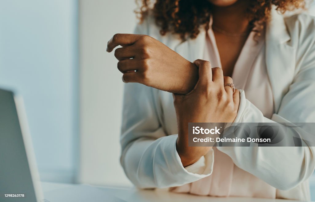 My wrist needs a bit of rest Shot of an unrecognisable businesswoman experiencing wrist pain while working in a modern office Pain Stock Photo