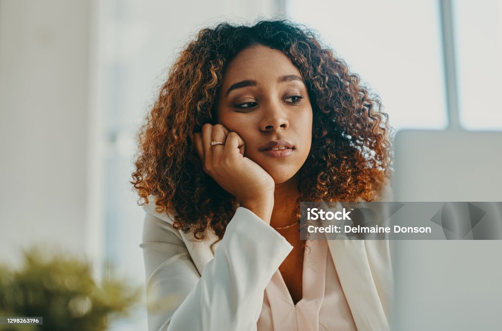 Nothing sucks the happy out of you like slow internet Shot of a young businesswoman looking bored while using a laptop in a modern office Disappointment Stock Photo