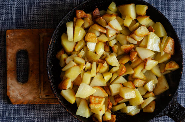 istock Pan fried potatoes on a wooden cutting board. 1298264282