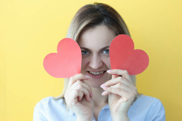istock Smiling woman holding red hearts in her hands 1298264383