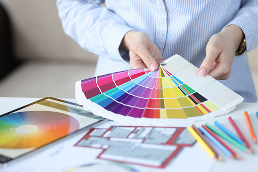 Female hands hold fan of color palette. Designer services in color selection concept