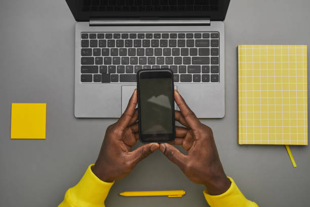 istock African Man Holding Phone at Workplace Flat Lay 1298265100