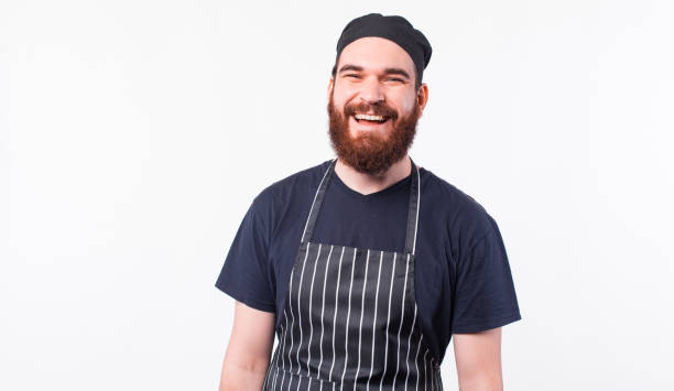istock Portrait of smiling bearded chef man over white background 1298265837