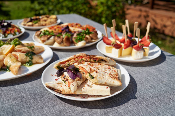 istock Buffet table with snacks, canape, sandwiches and appetizers at wedding reception outdoors, copy space. Serving food. Catering banquet table 1298265911