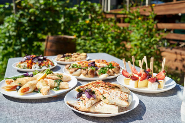 istock Buffet table with snacks, canape, sandwiches and appetizers at wedding reception outdoors, copy space. Serving food. Catering banquet table 1298265913