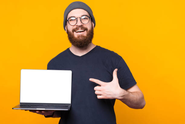 istock Cheerful handsome bearded man pointing at empty blank screen on laptop 1298266055