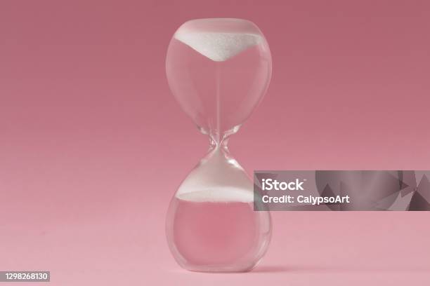 Upsidedown Hourglass On Pink Background Concept Of Reverse Time Stock Photo - Download Image Now