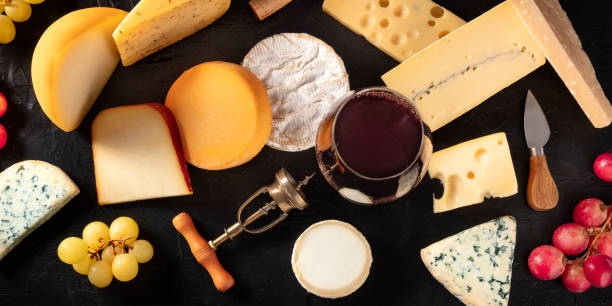 istock Cheese and wine panorama, various cheeses, shot from the top on a dark background 1298268543