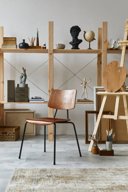 Unique artist workspace interior with stylish furniture, wooden easel, bookcase, artworks, painting accessories, decoration and elegant personal stuff. Modern work room for artist. Template. interior del espacio de trabajo del artista único con escritorio elegante, caballete de madera, estantería, obras de arte, accesorios de pintura, decoración y cosas personales elegantes. moderno cuarto de trabajo para artista. plantilla.