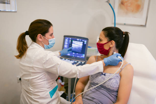 Ultrasound of thyroid gland Female doctor giving a young female patient an ultrasound of the thyroid gland. Cancer prevention thyroid gland stock pictures, royalty-free photos & images