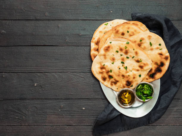 istock naan flatbreads on dark wood, copy space, top view 1298269731