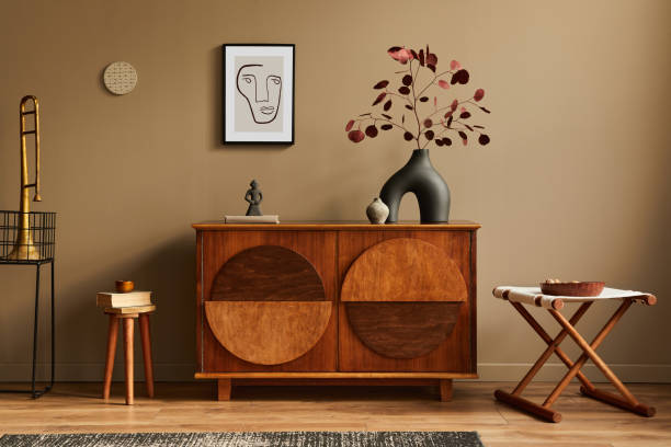 Stylish interior with design wooden commode, stool, dried flowers in vase, unique decoration, carpet, mock up poster frame and elegant personal accessories. Modern living room in classic house. Stylish interior with design wooden commode, mock up poster frame and elegant personal accessories. Modern living room in classic house. art deco vase stock pictures, royalty-free photos & images