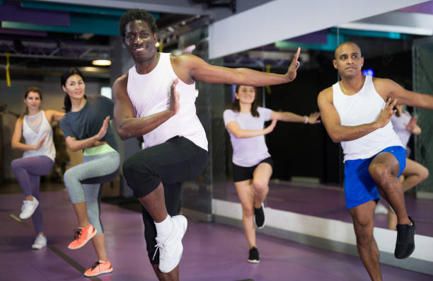 Emotional man doing exercises at dance class Portrait of excited man dancing during group class in dance center cardiovascular exercise stock pictures, royalty-free photos & images