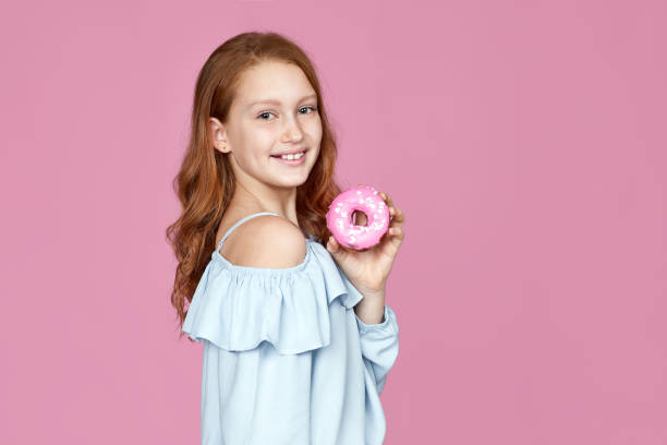 cute attractive child girl holding yummy donut