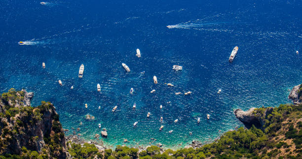 Panoramic aerial plunging view from Capri island (Italy) Panoramic aerial plunging view from Capri island (Italy). Seascape from Anacapri, famous blue bay in the Mediterranean Sea coast, a sunny summer day. – Image giardini naxos stock pictures, royalty-free photos & images