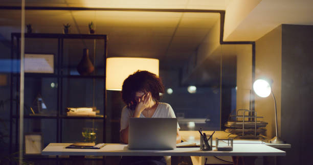 A burdened mind is an unproductive one Shot of a young businesswoman looking stressed while using a laptop during a late night at work burnout stock pictures, royalty-free photos & images
