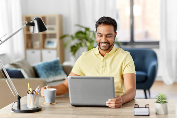 istock man with laptop drinking coffee at home office 1298273216
