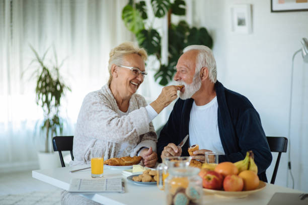 istock Beautiful senior couple having breakfast at home 1298273417