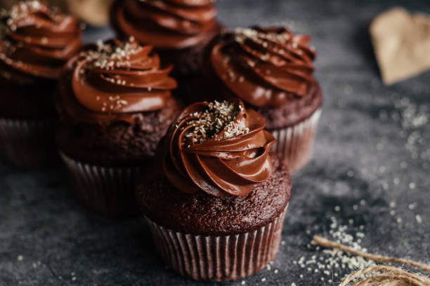 fotografii de stoc, fotografii și imagini scutite de redevențe cu delicioase cupcakes de ciocolată. cupcakes pe o masă de beton - chocolate icing