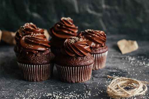 Delicious chocolate cupcakes. Cupcakes on a concrete table. Chocolate biscuit and chocolate ganache