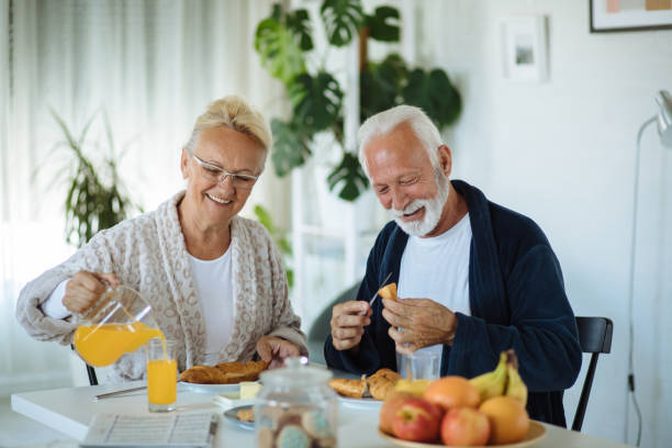 istock Beautiful senior couple having breakfast at home 1298274290