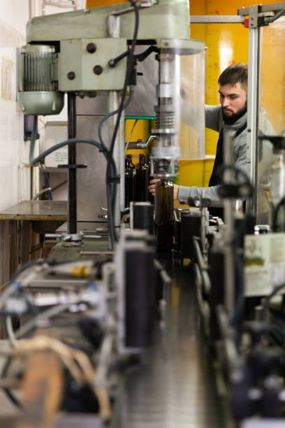 Guy working on olive oil bottling conveyor
