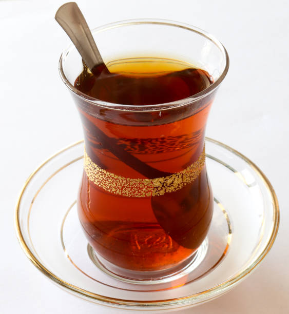 istock Turkish style black tea, tea glass and teaspoon in it. on a white background. 1298275007