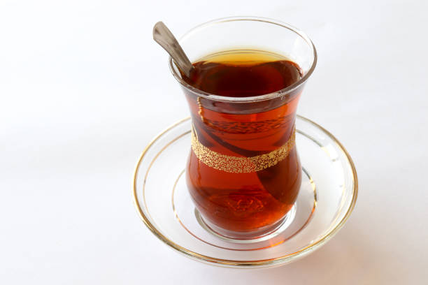 istock Turkish style black tea, tea glass and teaspoon in it. on a white background. 1298275065