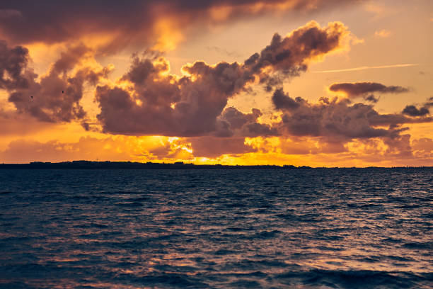 istock a beautiful yellow sunset by water 1298276362