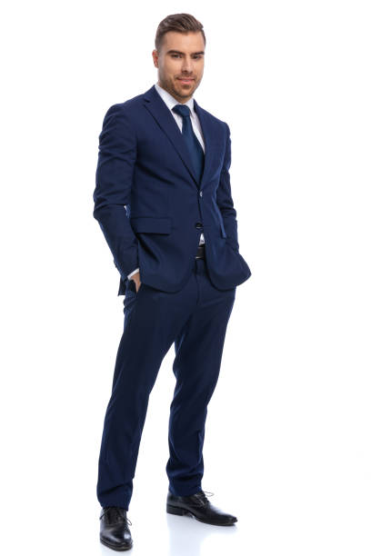 istock smiling young man in navy blue suit holding hands in pockets 1298278761