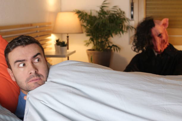 istock Terrified man seeing a monster in his bedroom 1298279070