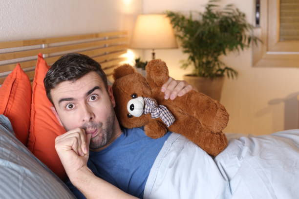 istock Adult sleeping with teddy bear 1298279141