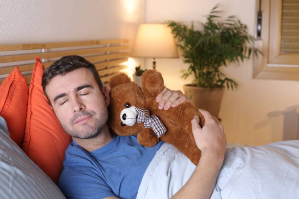 istock Adult sleeping with teddy bear 1298280048