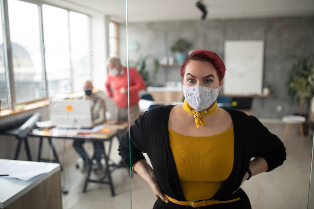 istock Confident female architect with protective face mask in modern office 1298280707