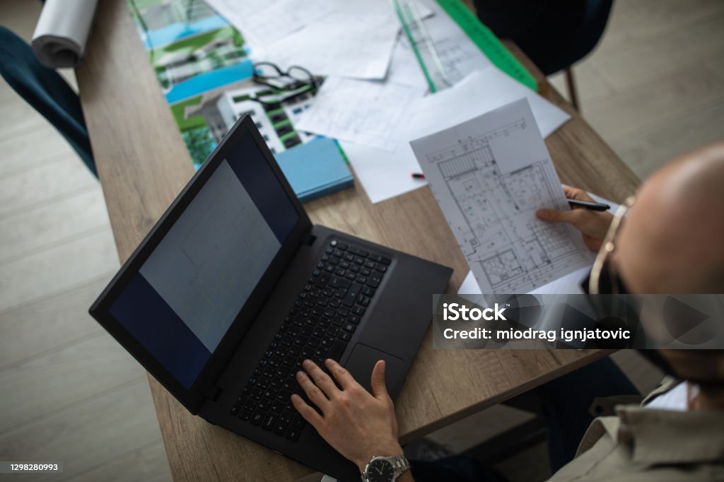 Architects Using Computer Architect Using Computer And Working On Floor Plan In Office Stock ...