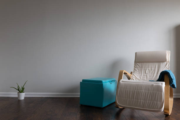 Relax atmosphere room with  hardwood parquet floor and celery colored wall with a rocking chair and teal color thrown blanked placed on the armrest. Cactus and an ottoman.
