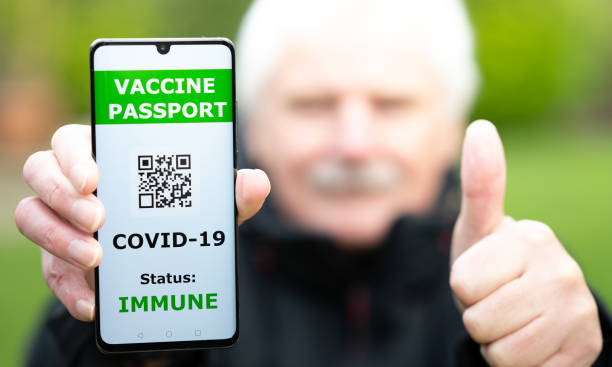 Senior man showing a vaccine passport on a mobile phone, which indicates a vaccination against covid-19. Senior man showing a vaccine passport on a mobile phone, which indicates a vaccination against covid-19. vaccine passport photos stock pictures, royalty-free photos & images