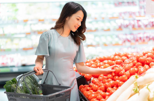 Asian woman shopping The young girl is choosing to buy vegetables at the supermarket shopping asia stock pictures, royalty-free photos & images