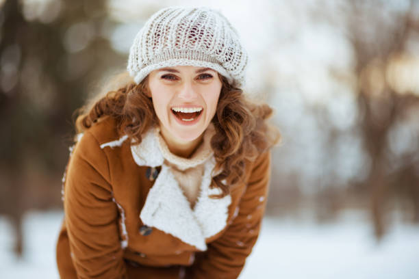 retrato de mulher feliz lá fora no parque da cidade no inverno - wind textile women retro revival - fotografias e filmes do acervo