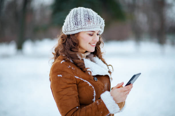 istock happy elegant woman sending text message using phone 1298285168