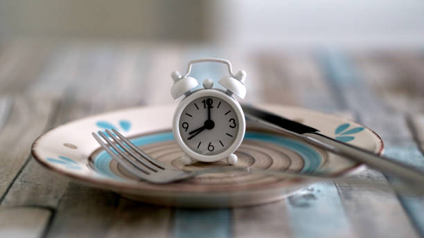 close up view of alarm clock on a plate intermittent fasting diet concept time to eat healthy