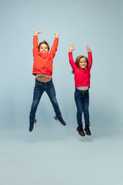 istock Happy children isolated on blue studio background. Look happy, cheerful, sincere. Copyspace. Childhood, education, emotions concept 1298288374